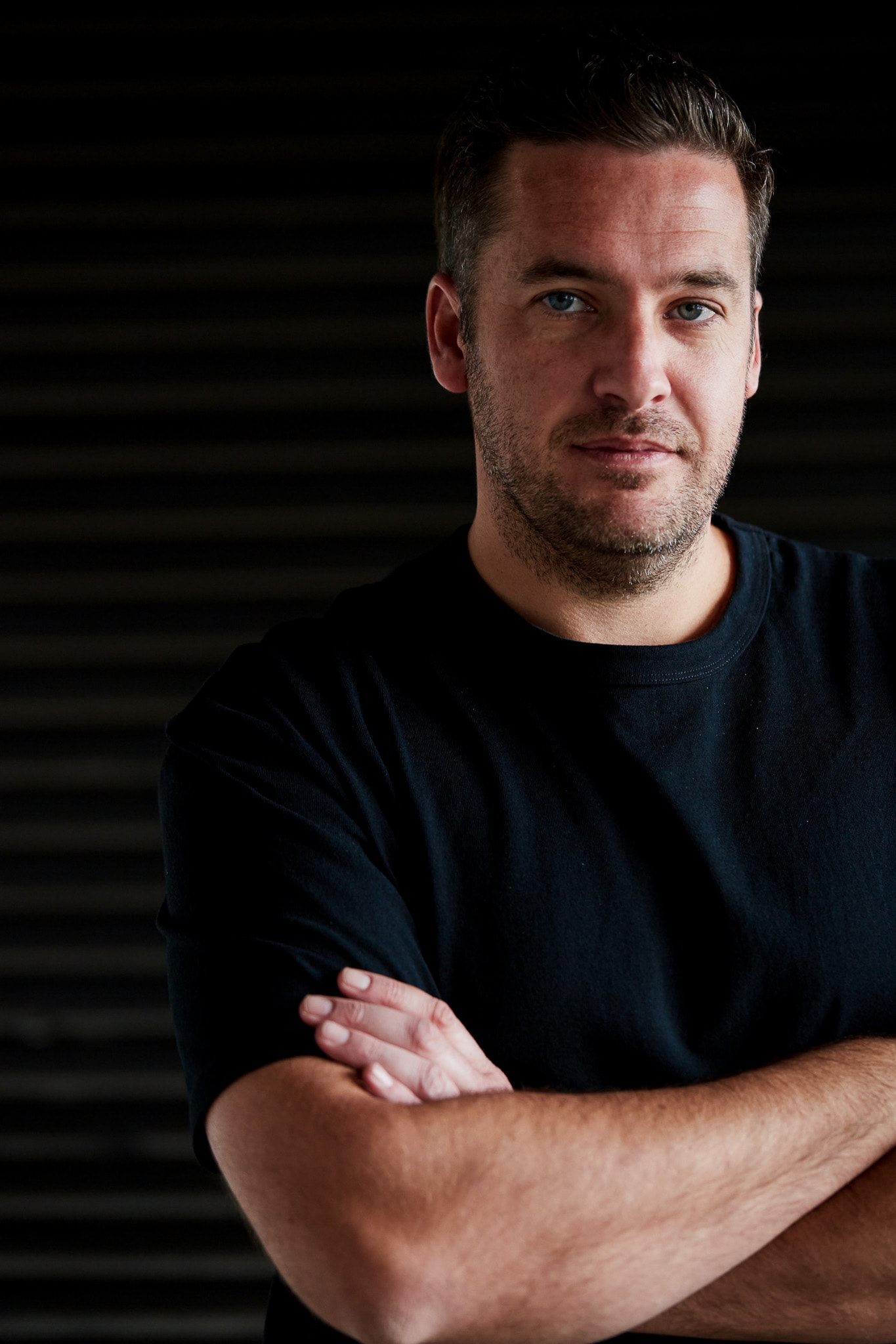 AI keynote speaker Gavin Reddrop, arms folded, in his studio